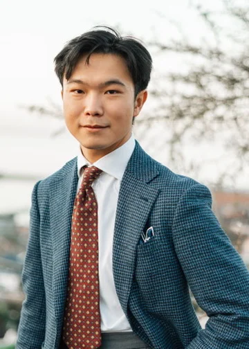 Yao Weng in a blue suit, standing outdoors
